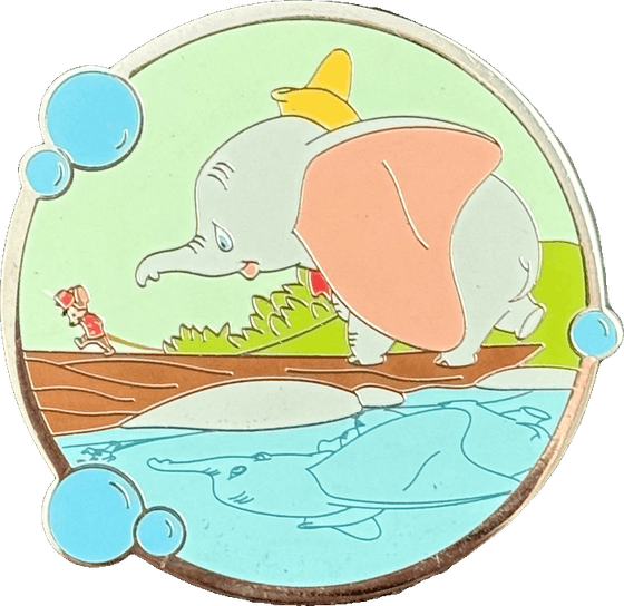 A round enamel pin of Dumbo on a log, looking at his reflection in the water